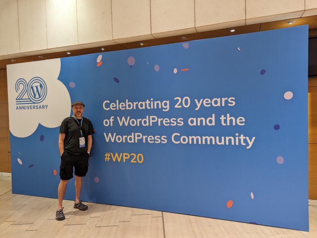 Aaron standing in front of WordPress Sign